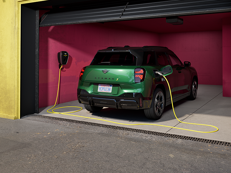 Vue arrière de la MINI Aceman Electric British Racing Green en charge dans un garage. 