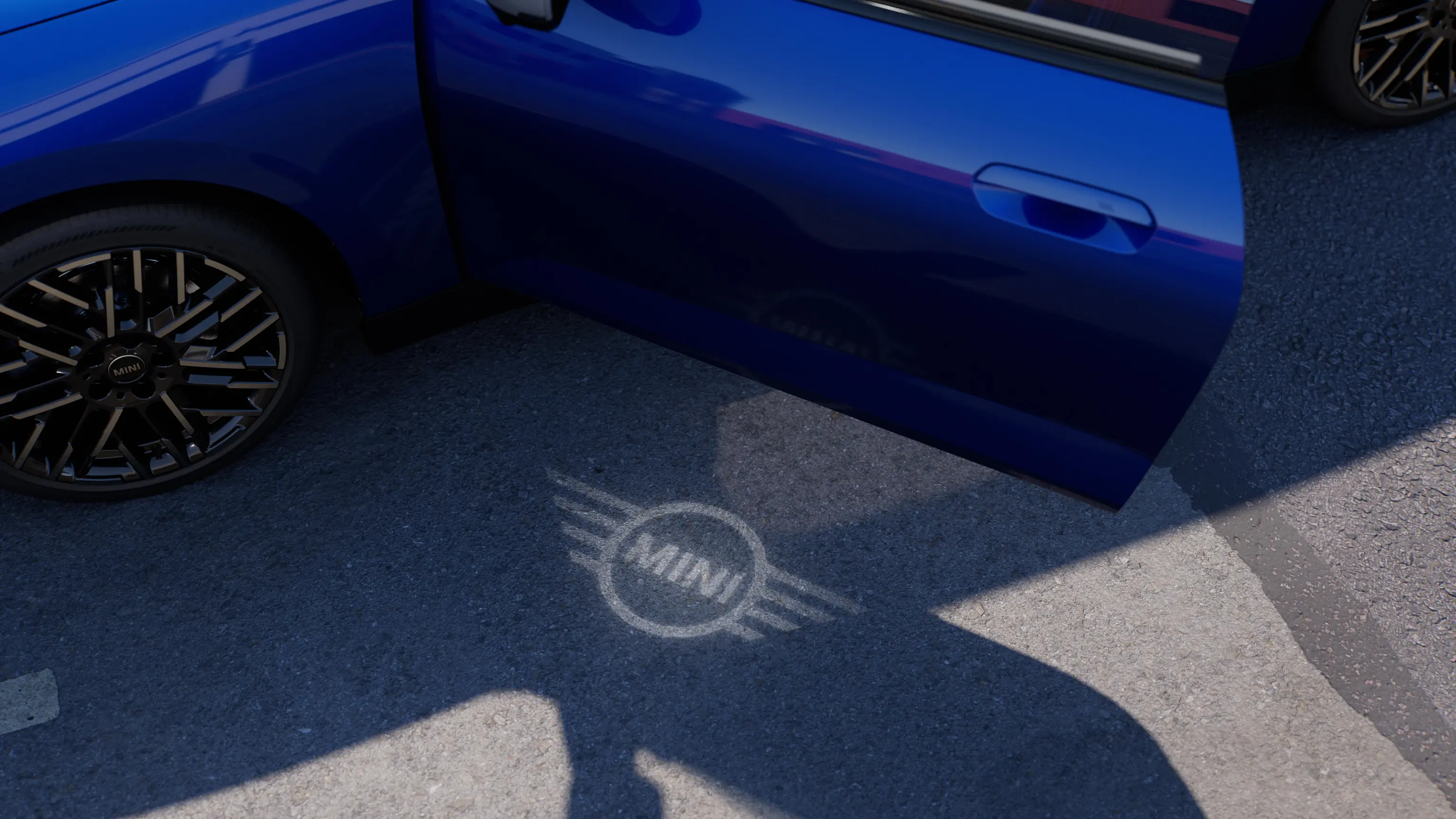 Vue extérieure de la MINI Cooper 100% électrique avec la porte ouverte et le logo MINI de bienvenue projeté au sol