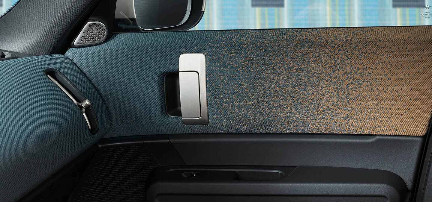 Vue rapprochée du design intérieur de la MINI Countryman Electric avec accent sur la porte et le tableau de bord.