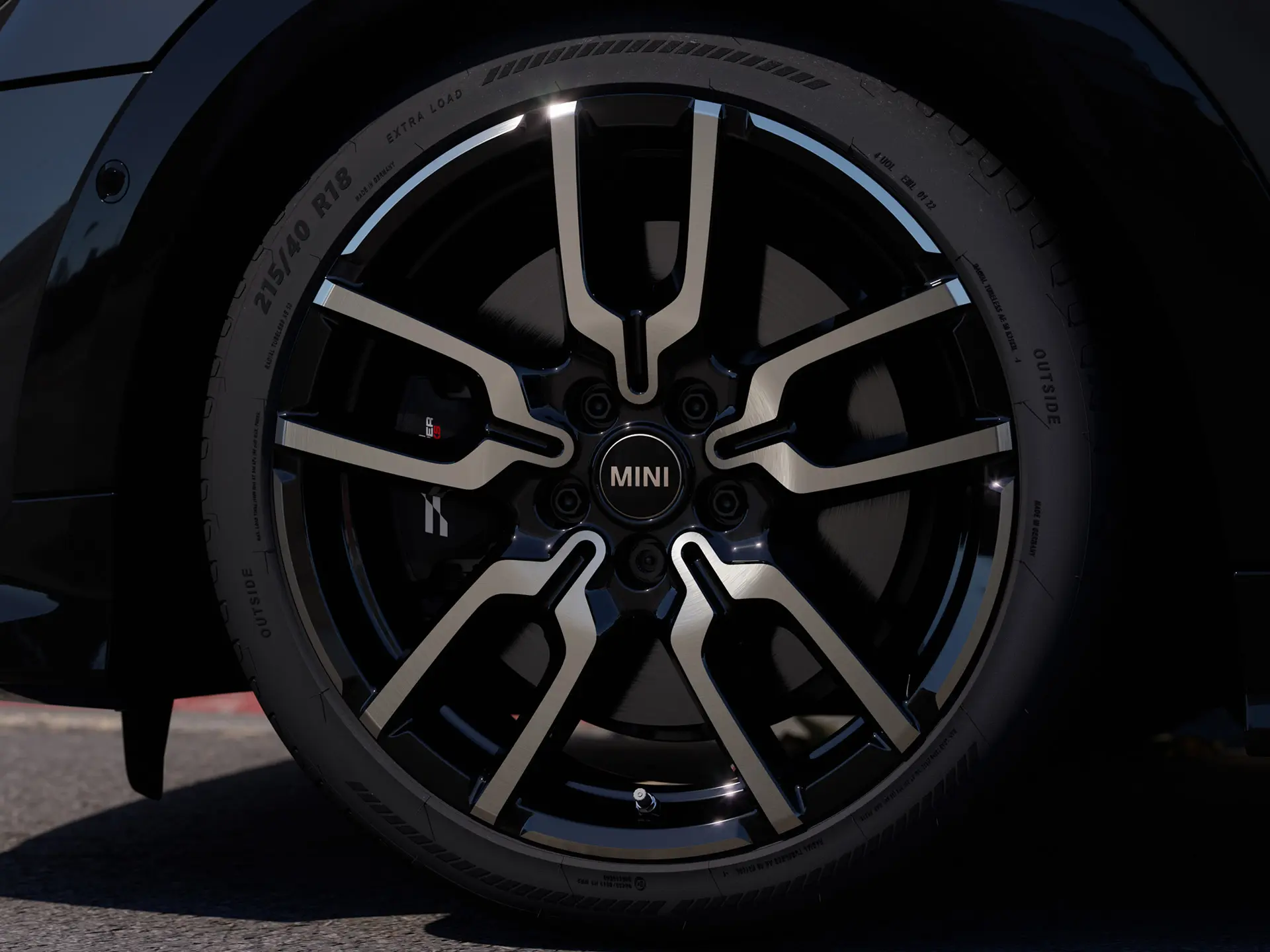 Nahaufnahme des Leichtmetallrads JCW Lap Spoke mit dem charakteristischen Design mit offenen Speichen in Jet Black. 