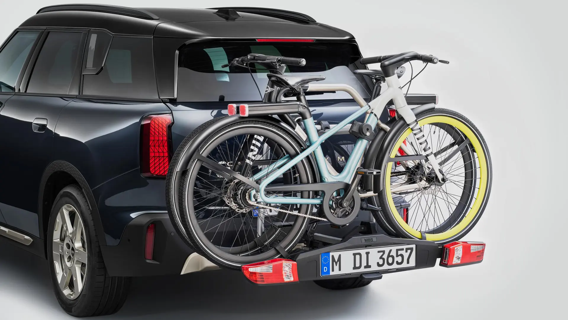 MINI Countryman noir avec porte-vélos arrière transportant deux VTT, vue arrière.