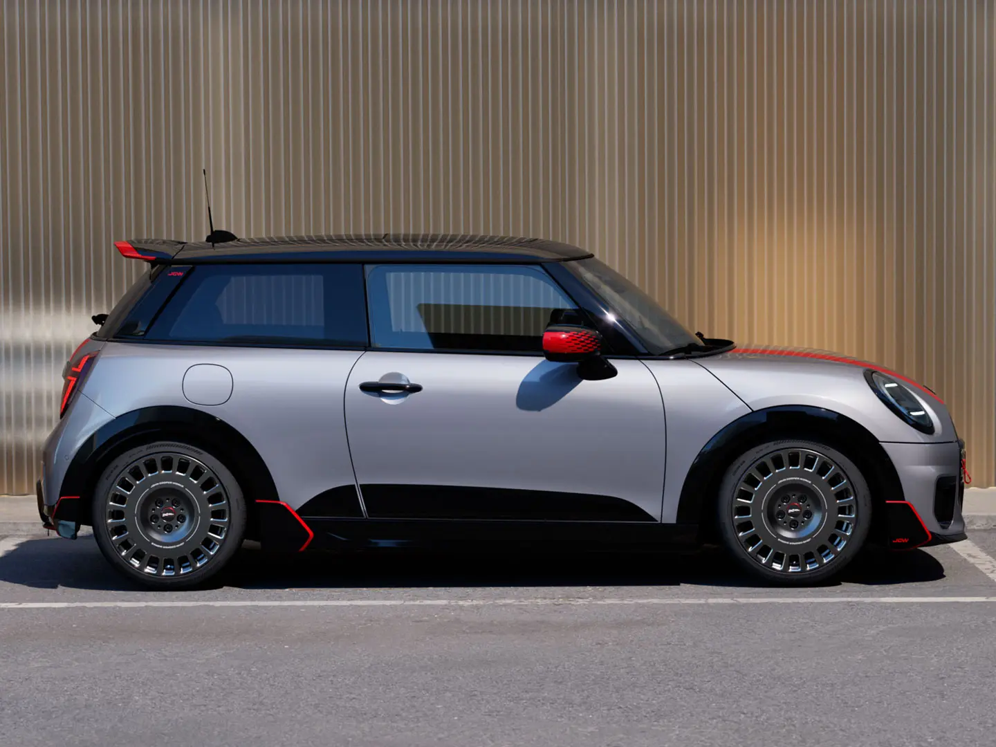 MINI Cooper 3-Türer in Melting Silver mit John Cooper Works Dachkantenspoiler für verbesserte aerodynamische Eigenschaften – Seitenansicht.