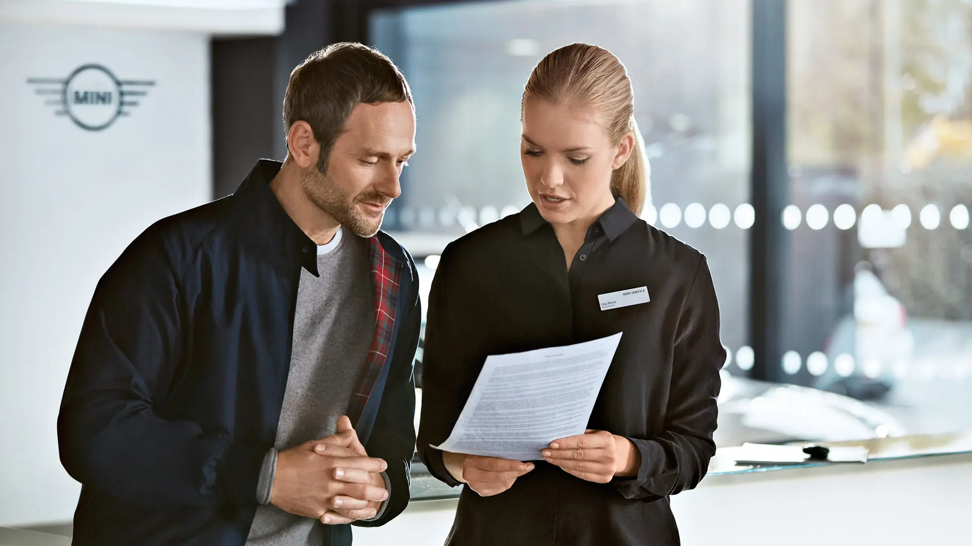 Ein MINI Serviceberater berät im MINI Center einen Kunden zu den Serviceplänen.